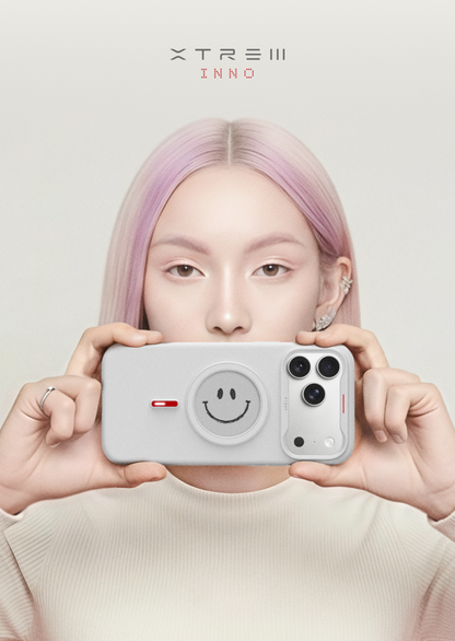 Person holding a phone with a smiley face camera lens cover, brand 'XTREEM INNO' visible