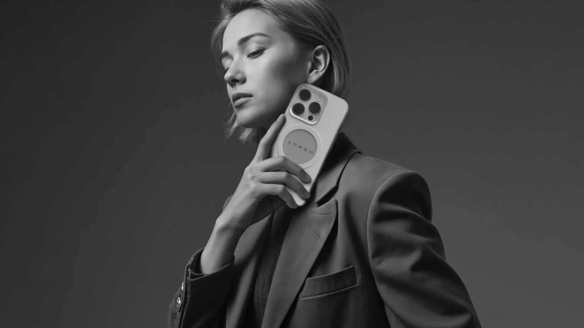 Woman holding a phone with a dark background