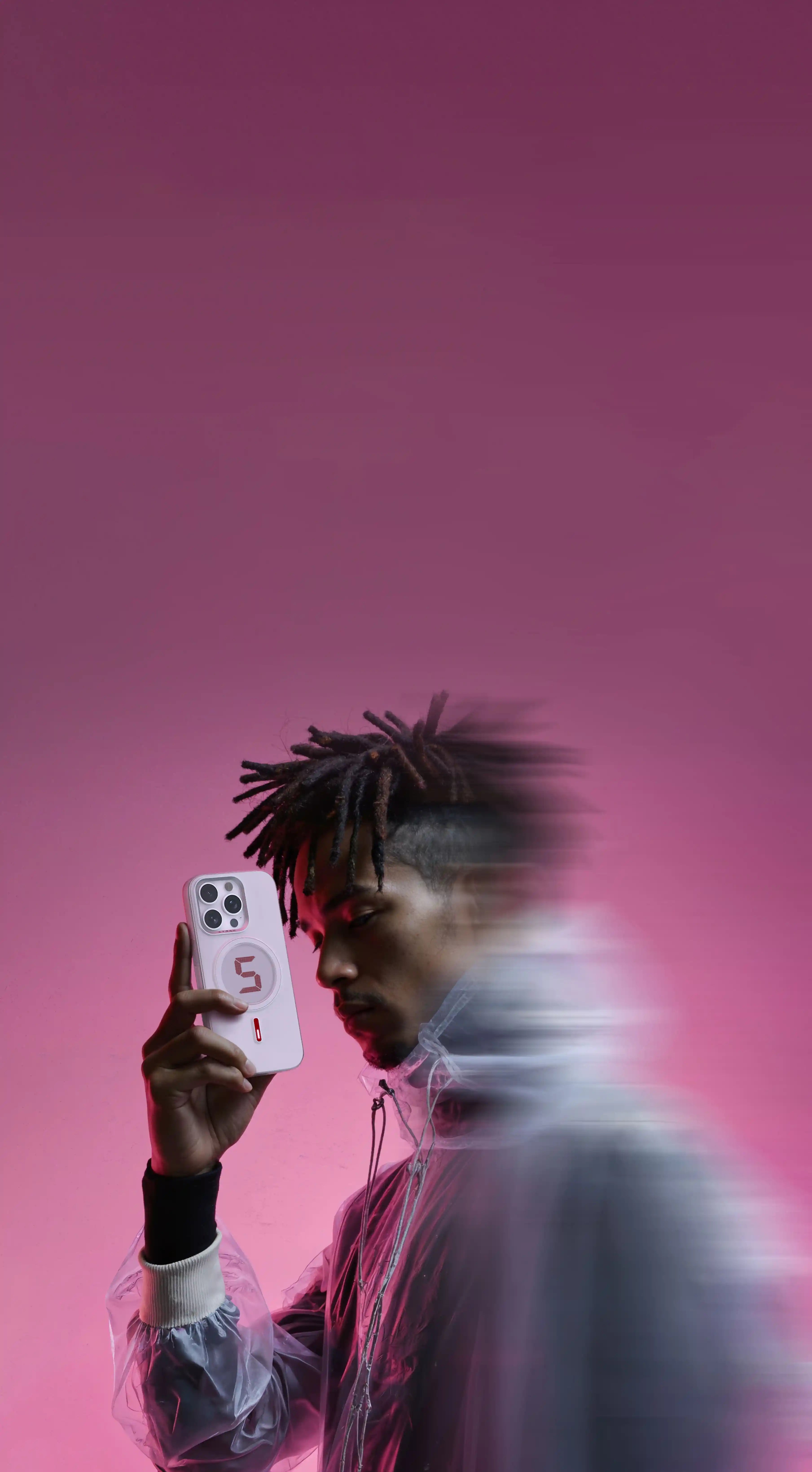 Person holding a phone with a pink gradient background