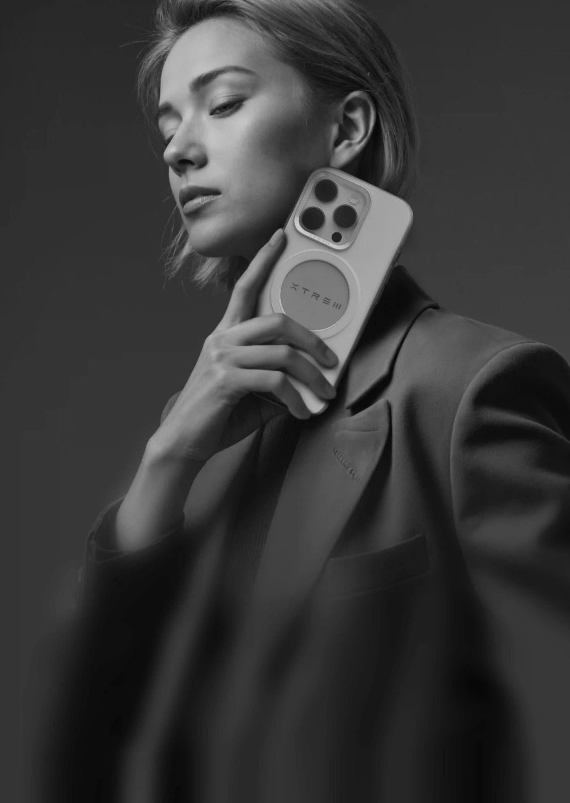 Person holding a phone with a dark background