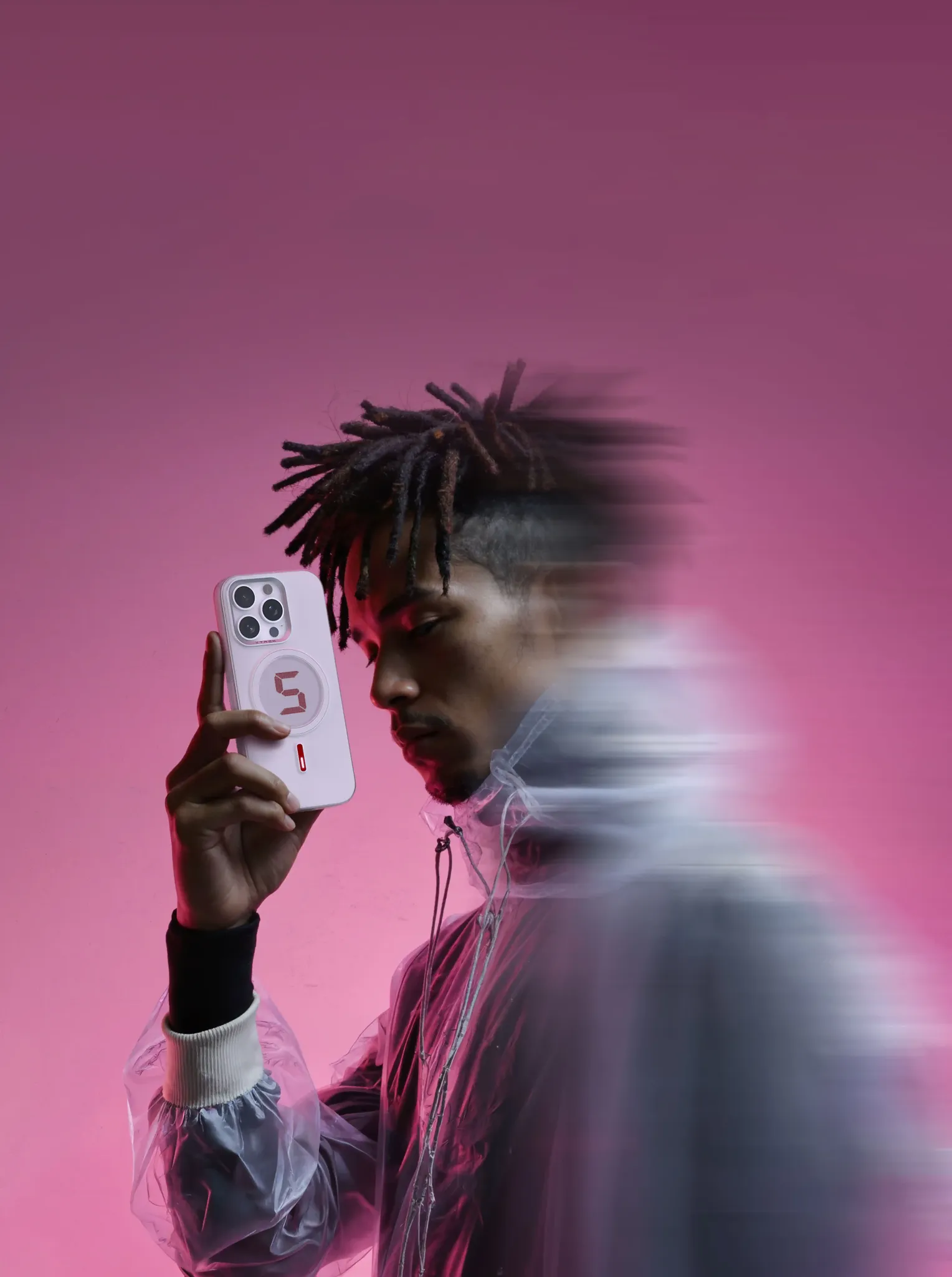 Person holding a phone with a pink background