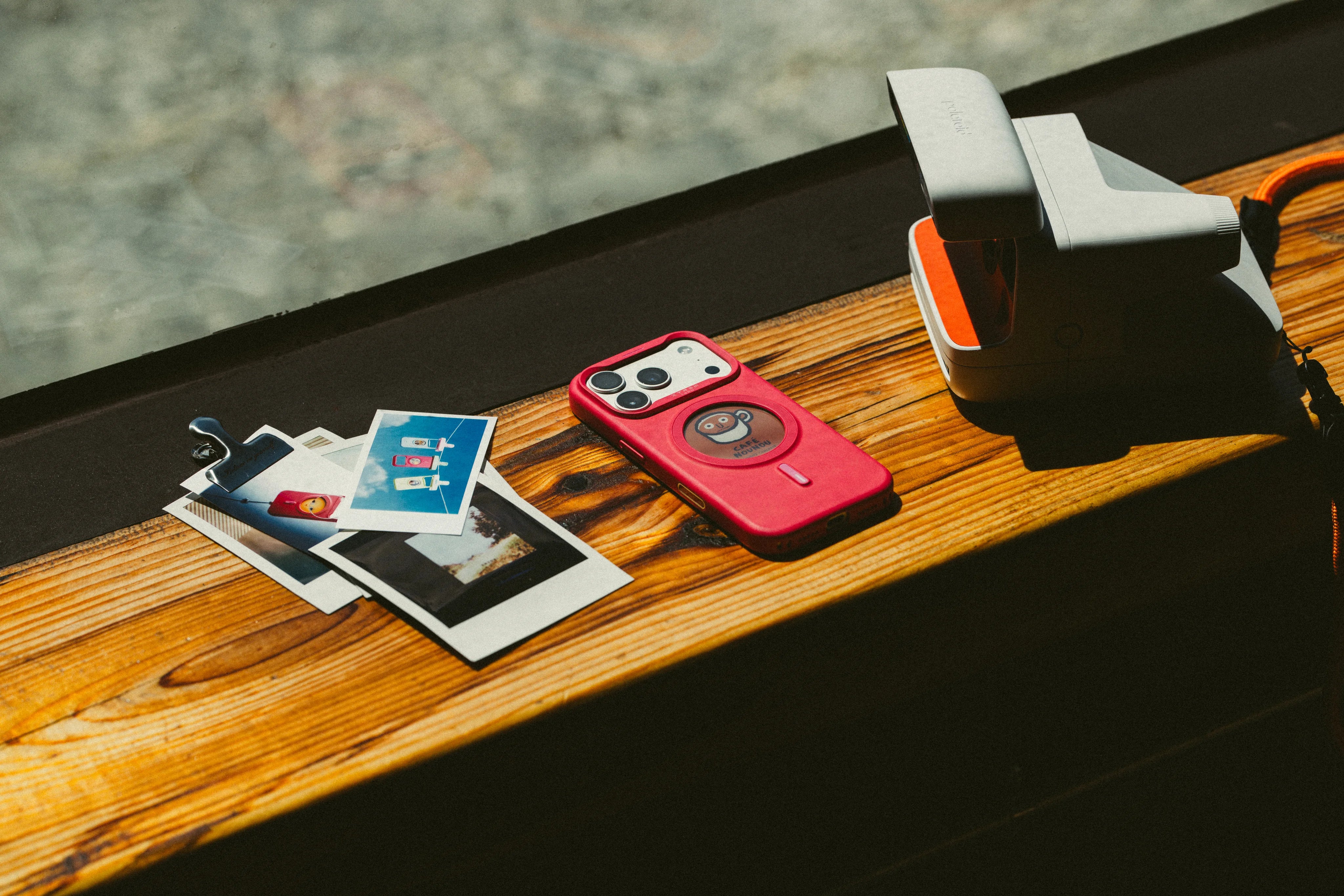 XTREM phone case and printed photos on a wooden table